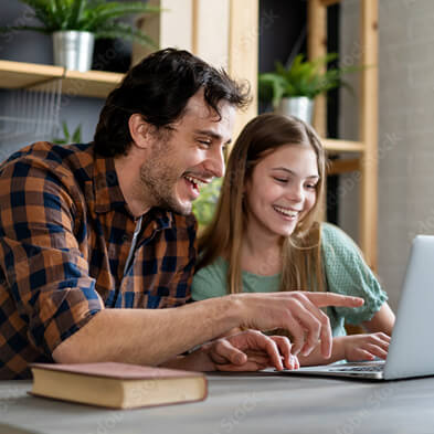 Two people sitting at table looking at laptop together, one pointing at screen, shelves with plants in background.